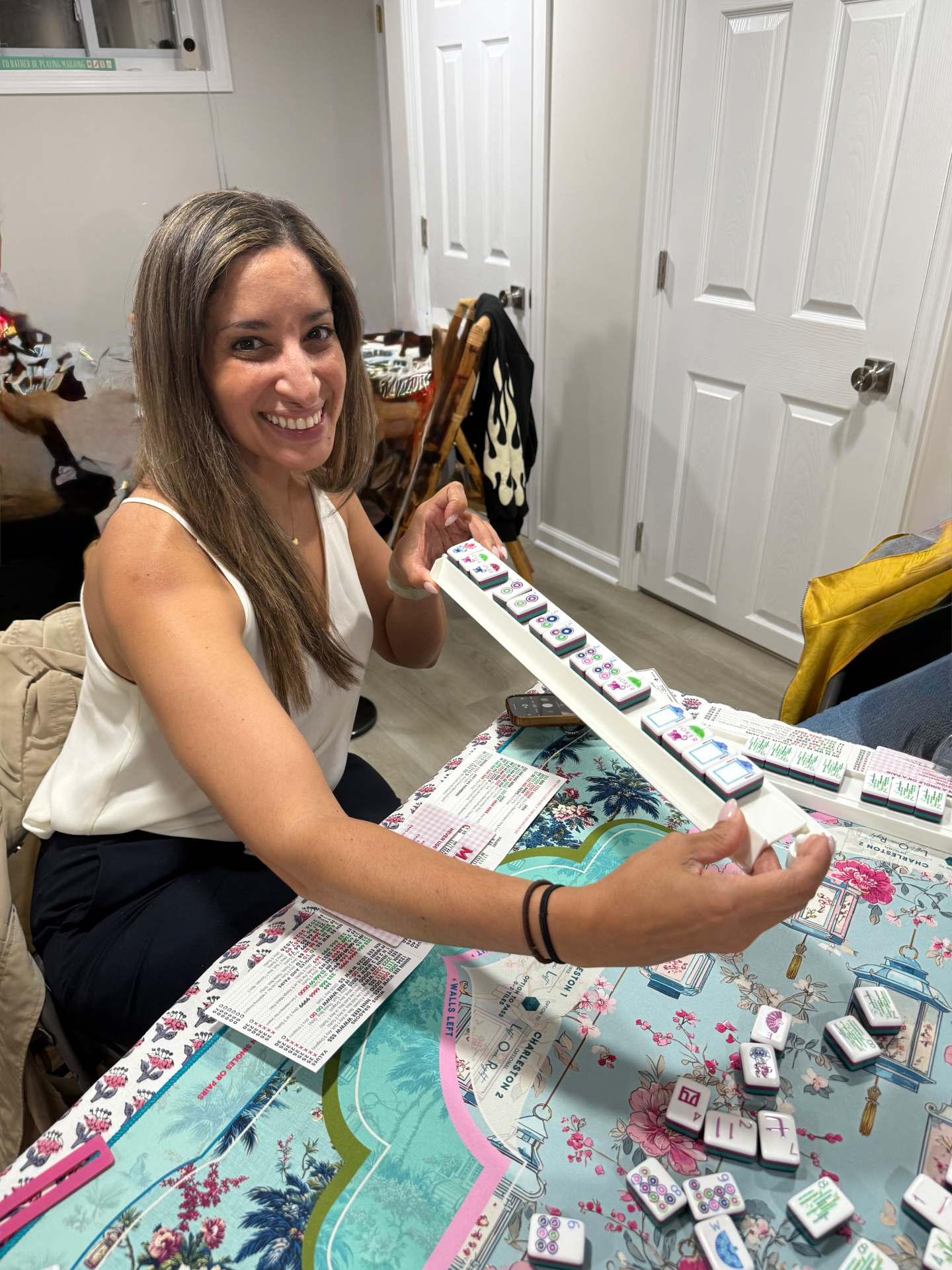 A smiling player showing her MahJongg rack during a game
